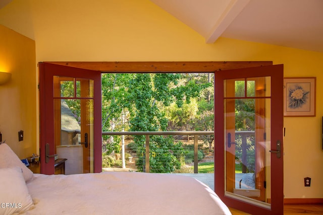 bedroom with multiple windows, vaulted ceiling with beams, and wood-type flooring