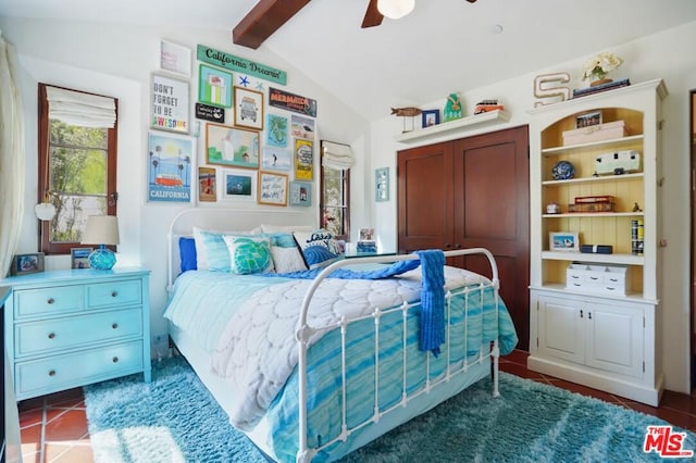 bedroom with ceiling fan, vaulted ceiling with beams, and dark tile flooring