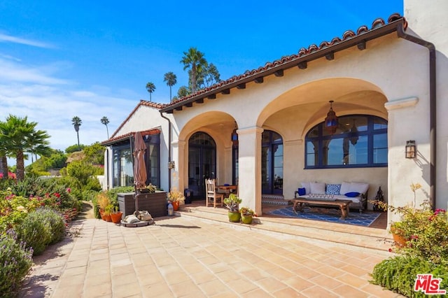 rear view of house featuring french doors and a patio area