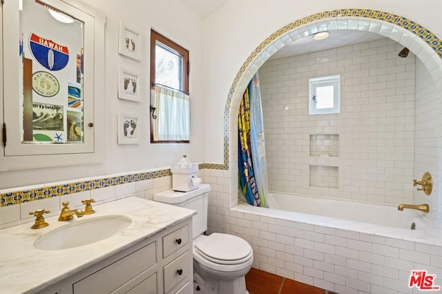 full bathroom with toilet, shower / tub combo with curtain, tile walls, large vanity, and tile floors