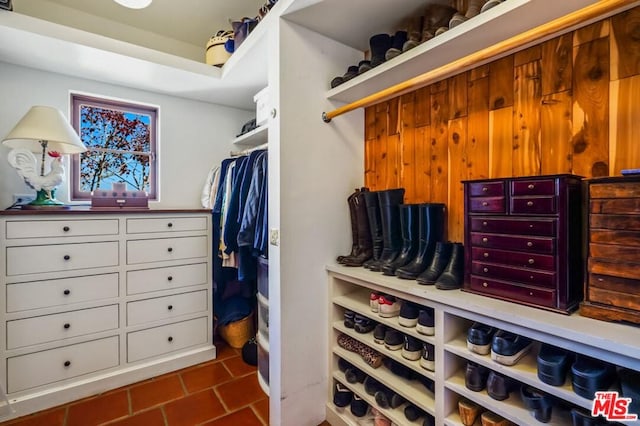 walk in closet featuring dark tile floors