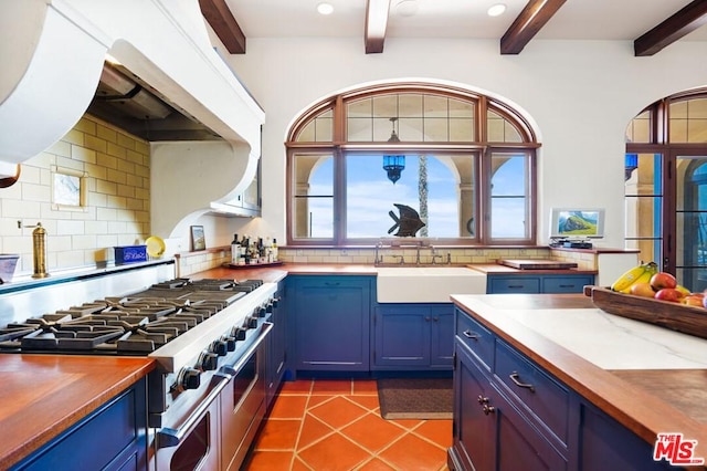 kitchen featuring double oven range, beam ceiling, tasteful backsplash, tile flooring, and sink