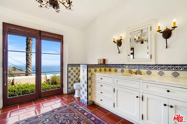 bathroom with toilet, tile flooring, vanity, and a water view