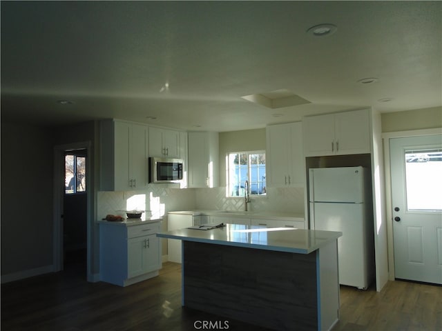 kitchen with white cabinets, a kitchen island, and a healthy amount of sunlight