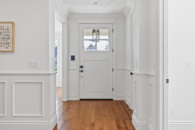 foyer with light hardwood / wood-style flooring and crown molding