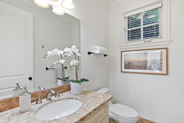 bathroom featuring crown molding, vanity, and toilet