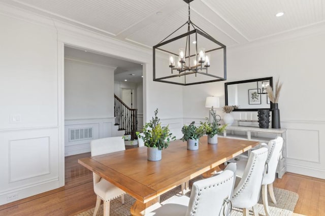 dining area featuring an inviting chandelier, light hardwood / wood-style flooring, and crown molding