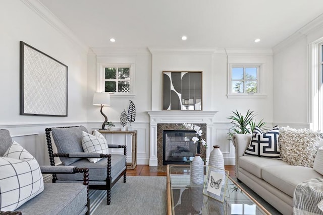 living room with hardwood / wood-style flooring, a fireplace, ornamental molding, and a wealth of natural light