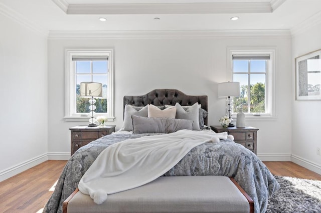 bedroom featuring multiple windows, hardwood / wood-style floors, and crown molding