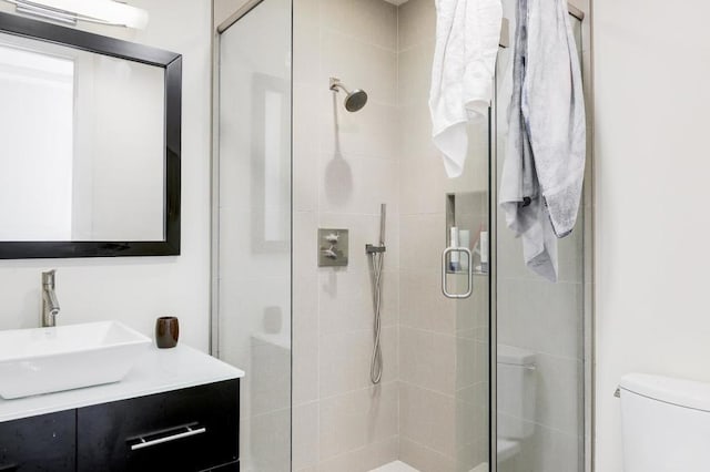 bathroom featuring an enclosed shower, vanity, and toilet