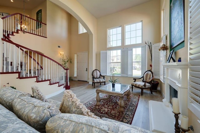 living room featuring a high ceiling, a notable chandelier, and wood-type flooring