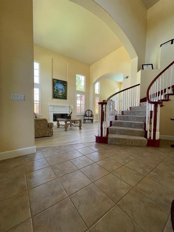 staircase featuring tile floors and a towering ceiling