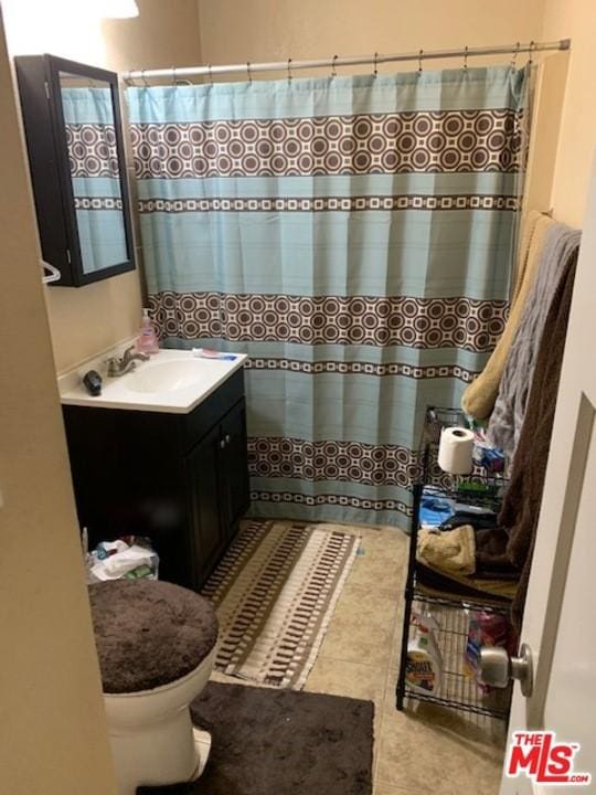 bathroom with tile floors, toilet, and vanity