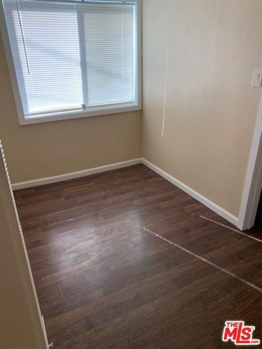 unfurnished room with dark wood-type flooring and a wealth of natural light