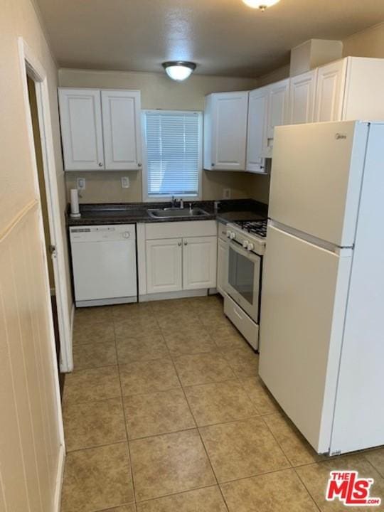 kitchen with light tile flooring, sink, white appliances, and white cabinets