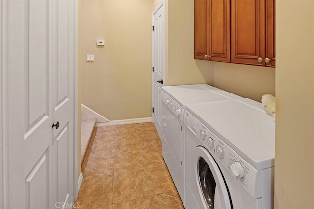 laundry area featuring cabinets, washer and dryer, and light tile flooring