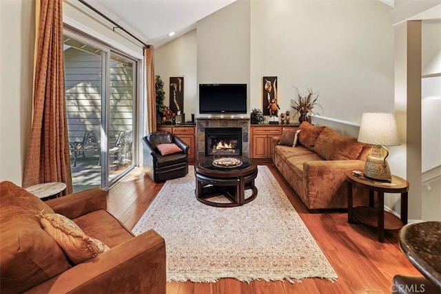 living room featuring a fireplace, lofted ceiling, and dark hardwood / wood-style floors