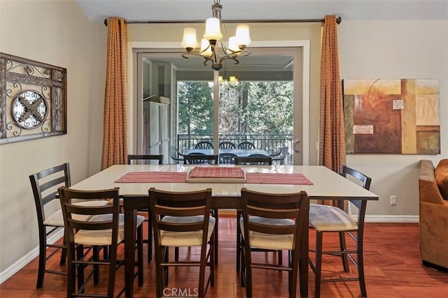 dining area with dark hardwood / wood-style flooring and a notable chandelier