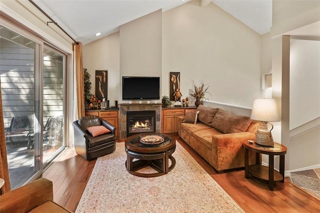 living room with lofted ceiling with beams, dark hardwood / wood-style floors, and a fireplace