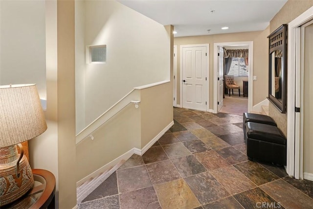 hallway with dark tile flooring