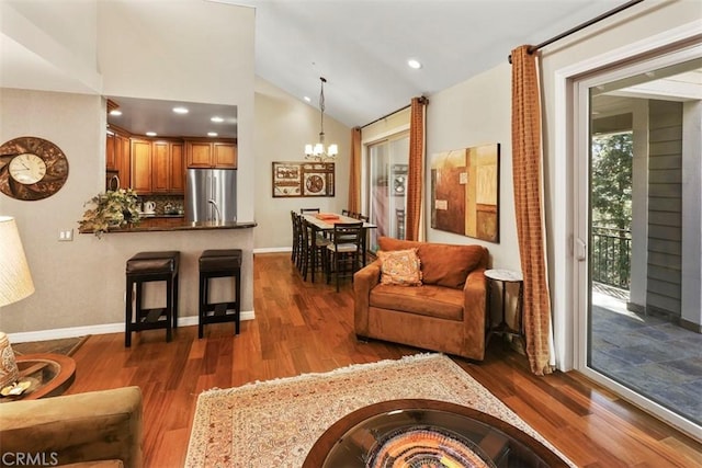 living room featuring dark hardwood / wood-style flooring, an inviting chandelier, and high vaulted ceiling