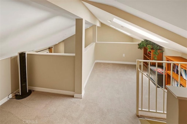 bonus room featuring lofted ceiling with skylight and light colored carpet