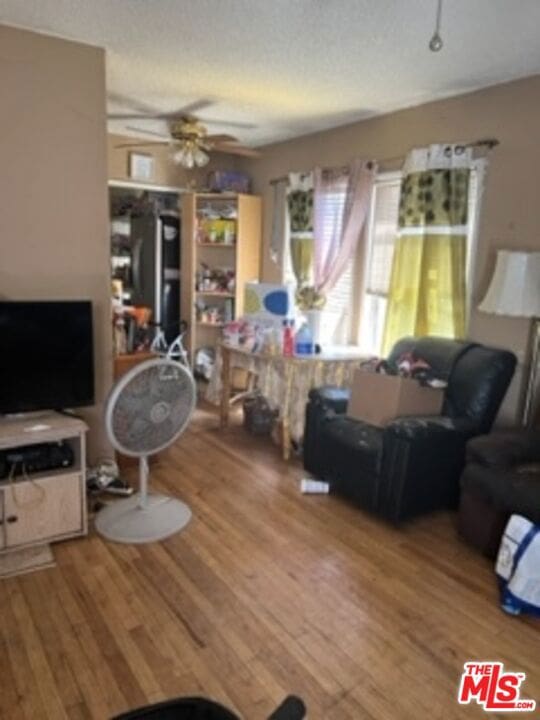 living room featuring ceiling fan and hardwood / wood-style floors