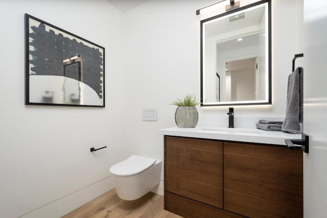 bathroom with hardwood / wood-style floors, toilet, and vanity