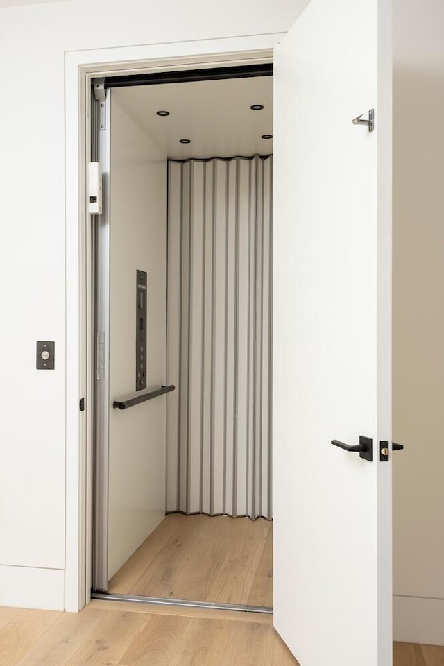 hall featuring elevator and light hardwood / wood-style floors