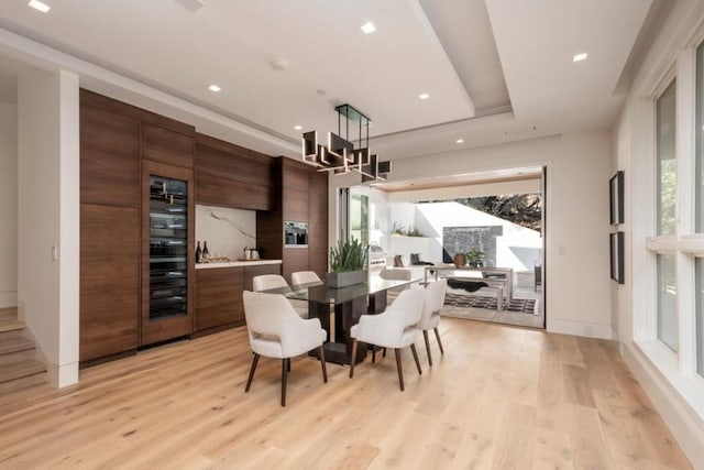 dining area with plenty of natural light, an inviting chandelier, and light wood-type flooring