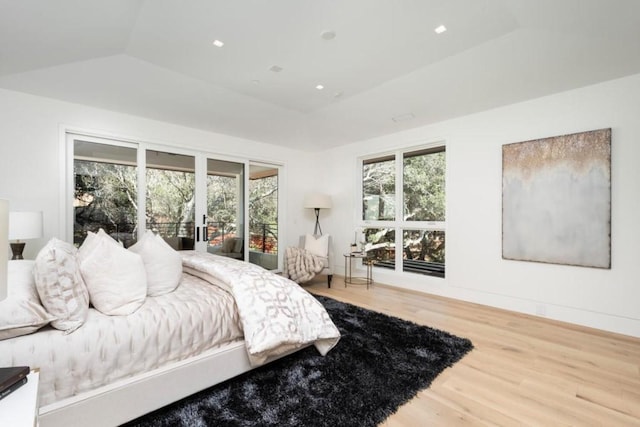 bedroom with lofted ceiling and light wood-type flooring