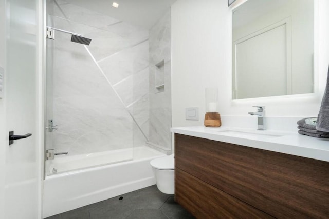 full bathroom featuring toilet, tile floors, vanity, and tiled shower / bath