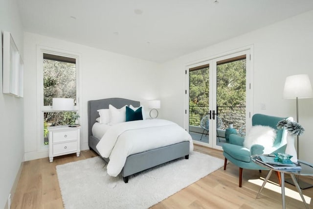 bedroom with light wood-type flooring, french doors, and access to exterior