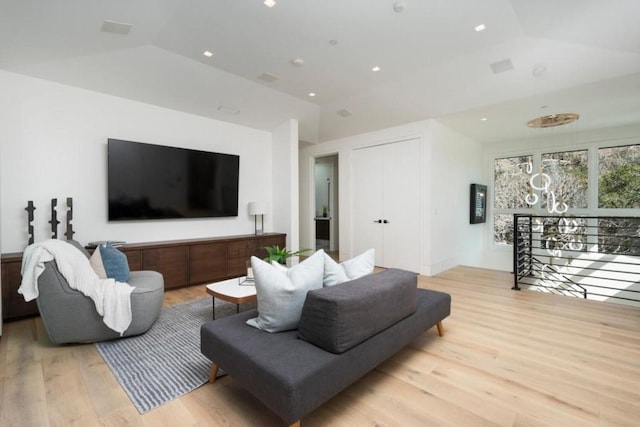 living room featuring lofted ceiling and light hardwood / wood-style flooring