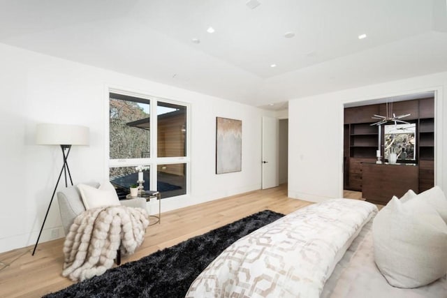 bedroom featuring vaulted ceiling, light hardwood / wood-style floors, a closet, and a walk in closet