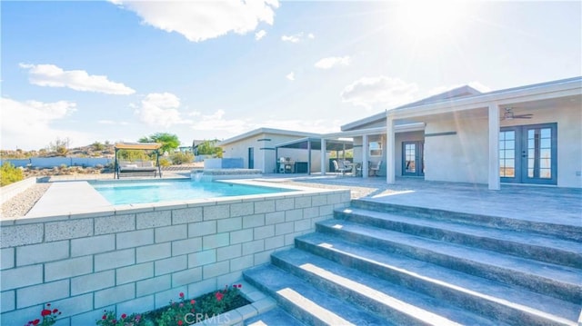 view of pool featuring french doors, a patio area, and ceiling fan