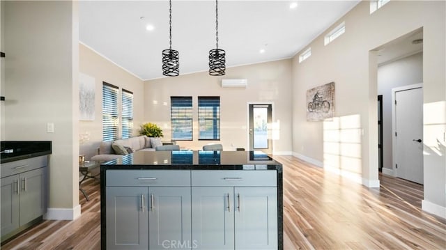 kitchen featuring hanging light fixtures, high vaulted ceiling, light wood-type flooring, crown molding, and an AC wall unit