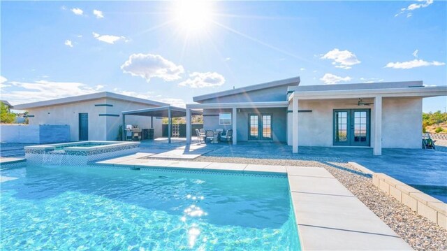 view of swimming pool with a patio, an in ground hot tub, ceiling fan, and french doors