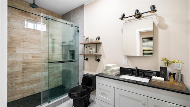 bathroom featuring a shower with shower door, toilet, and vanity