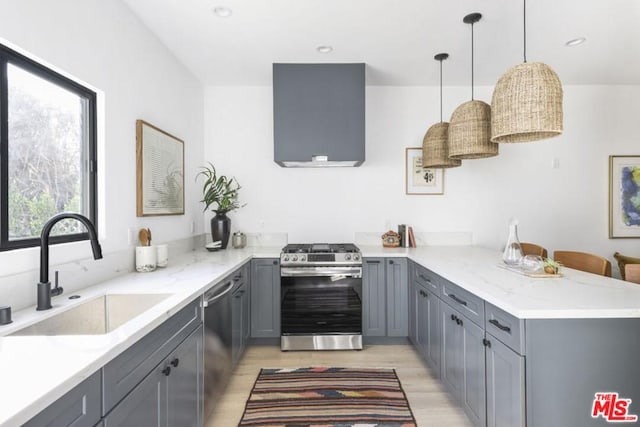 kitchen with appliances with stainless steel finishes, light hardwood / wood-style floors, sink, gray cabinets, and pendant lighting