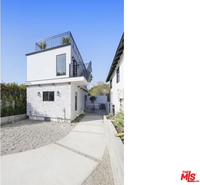 rear view of house with a balcony and central air condition unit