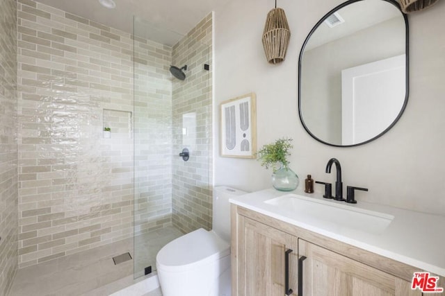 bathroom featuring a shower with shower door, toilet, and vanity