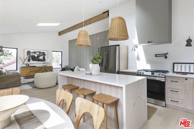 kitchen with a breakfast bar, appliances with stainless steel finishes, light stone counters, vaulted ceiling with beams, and light hardwood / wood-style flooring