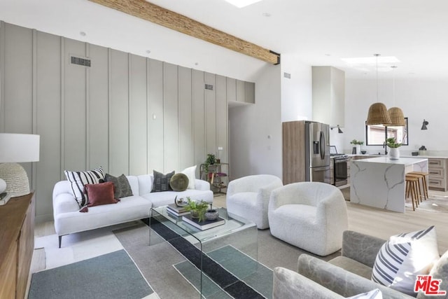 living room featuring light hardwood / wood-style flooring and beamed ceiling