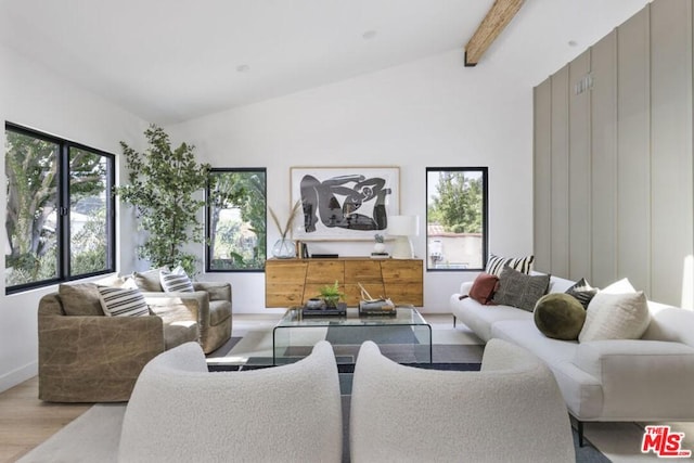 living room with vaulted ceiling with beams, light hardwood / wood-style floors, and a healthy amount of sunlight