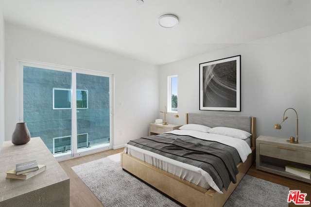 bedroom featuring access to exterior and light hardwood / wood-style flooring