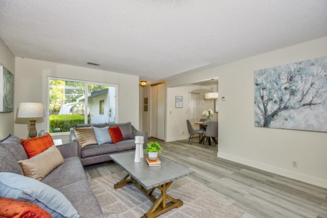 living room featuring a textured ceiling and light hardwood / wood-style flooring