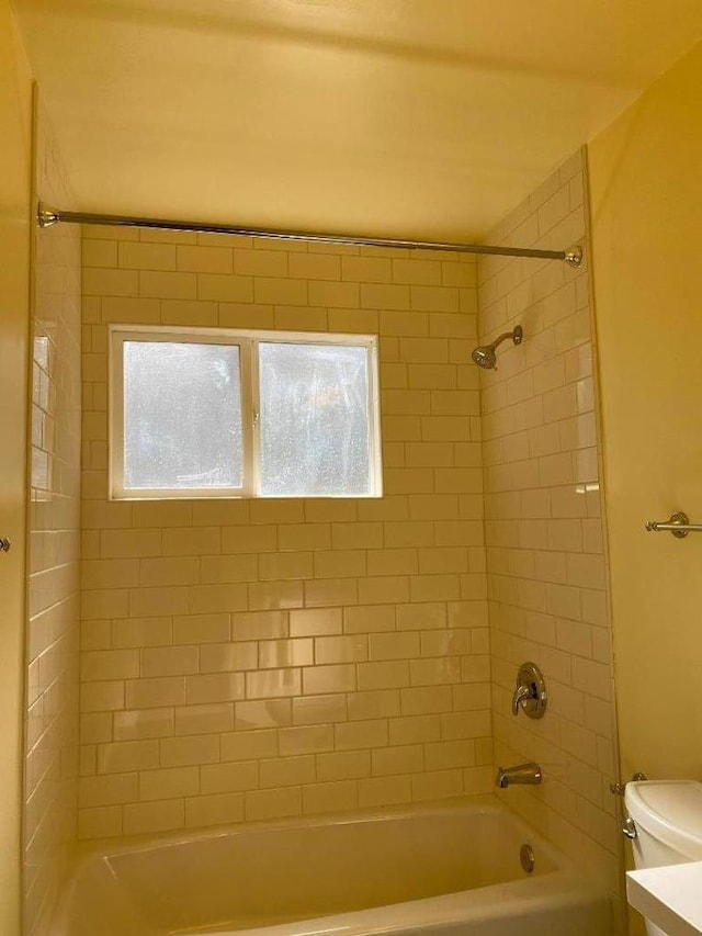 full bathroom featuring toilet, vanity, and tiled shower / bath