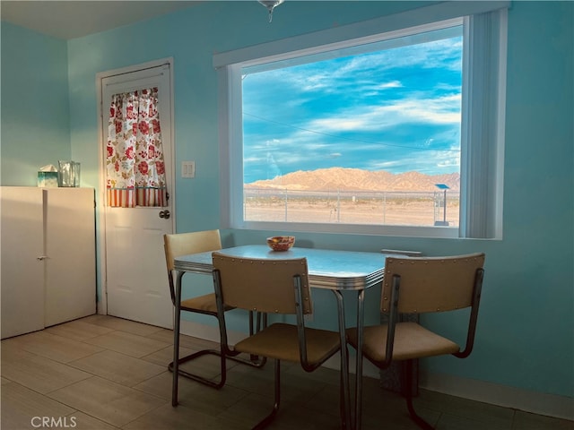 dining room with a mountain view and light tile floors