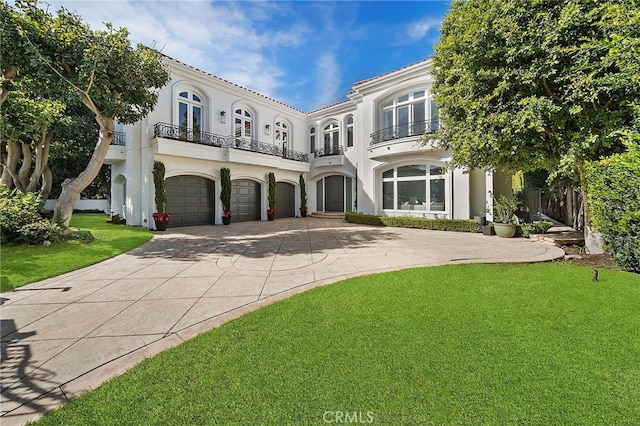 view of front facade featuring a balcony, a front lawn, and a garage